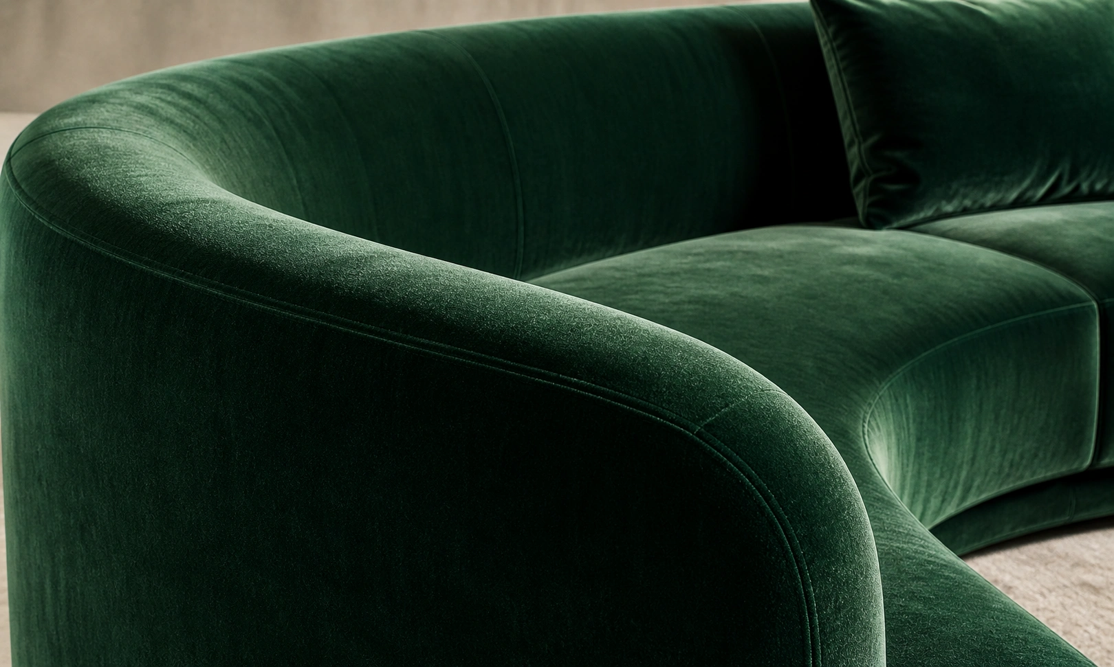 Velvet upholstered curved sofa in emerald green
