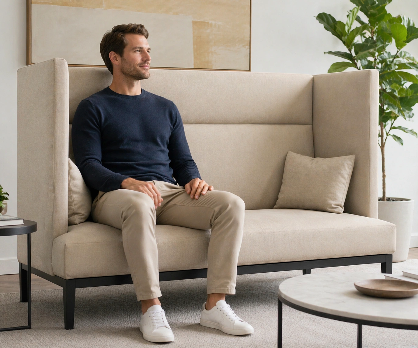 Tall person sitting comfortably on a high back sofa