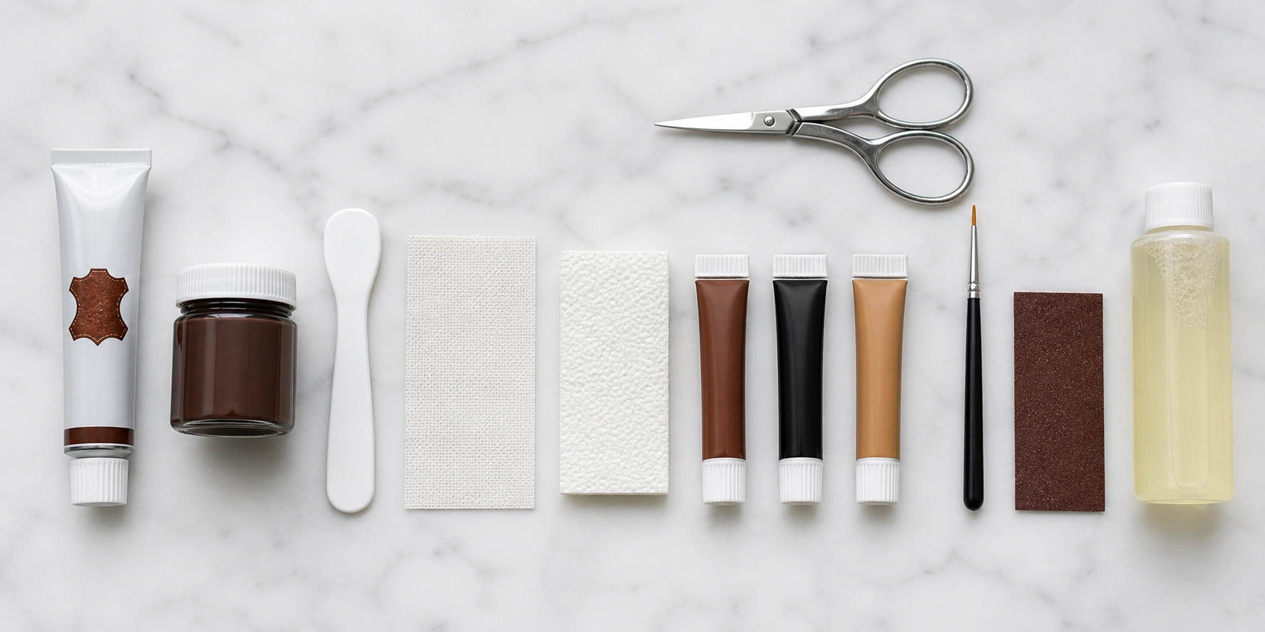 Complete leather repair kit spread out showing adhesive compound color tubes applicator tools and sandpaper