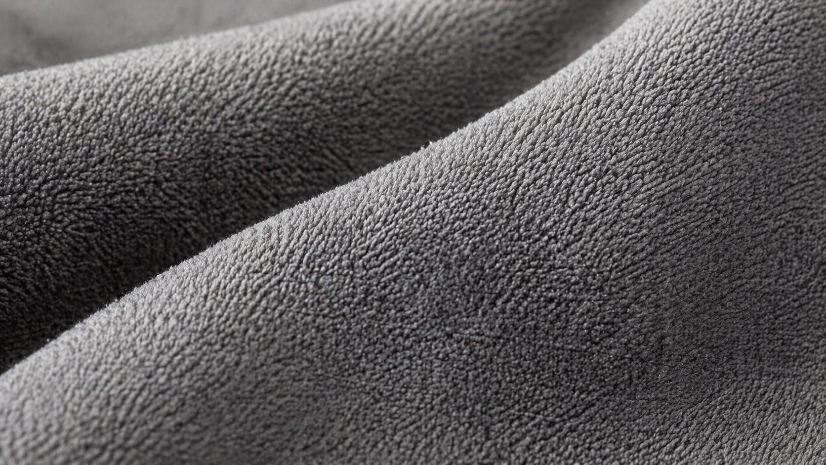 Close-up of microfiber fabric texture showing the fine polyester fibers and smooth surface