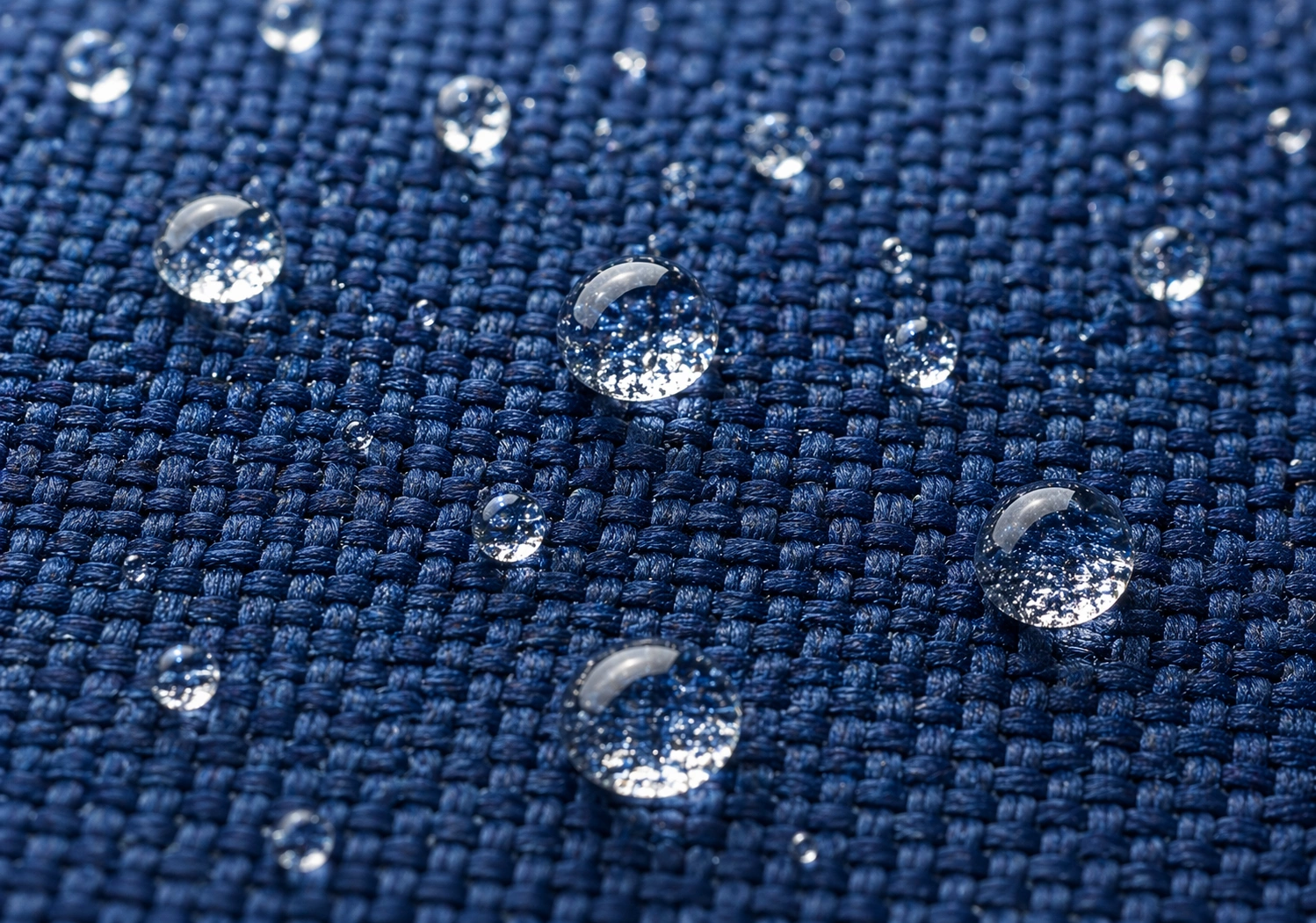 Close-up of outdoor sofa cushion fabric showing water beading on surface