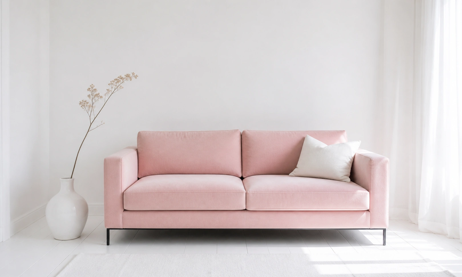 Blush pink upholstered sofa in a minimalist white living room