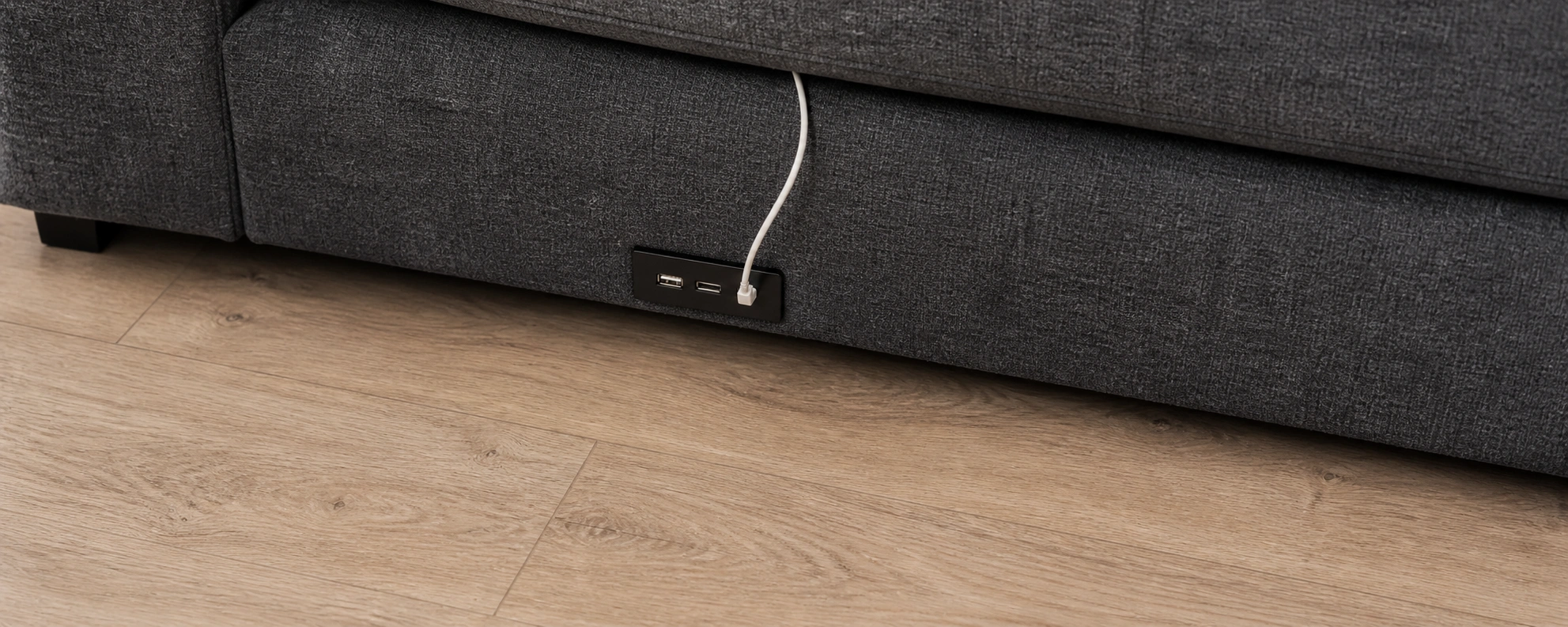 USB ports positioned at the base of a sofa near the floor level