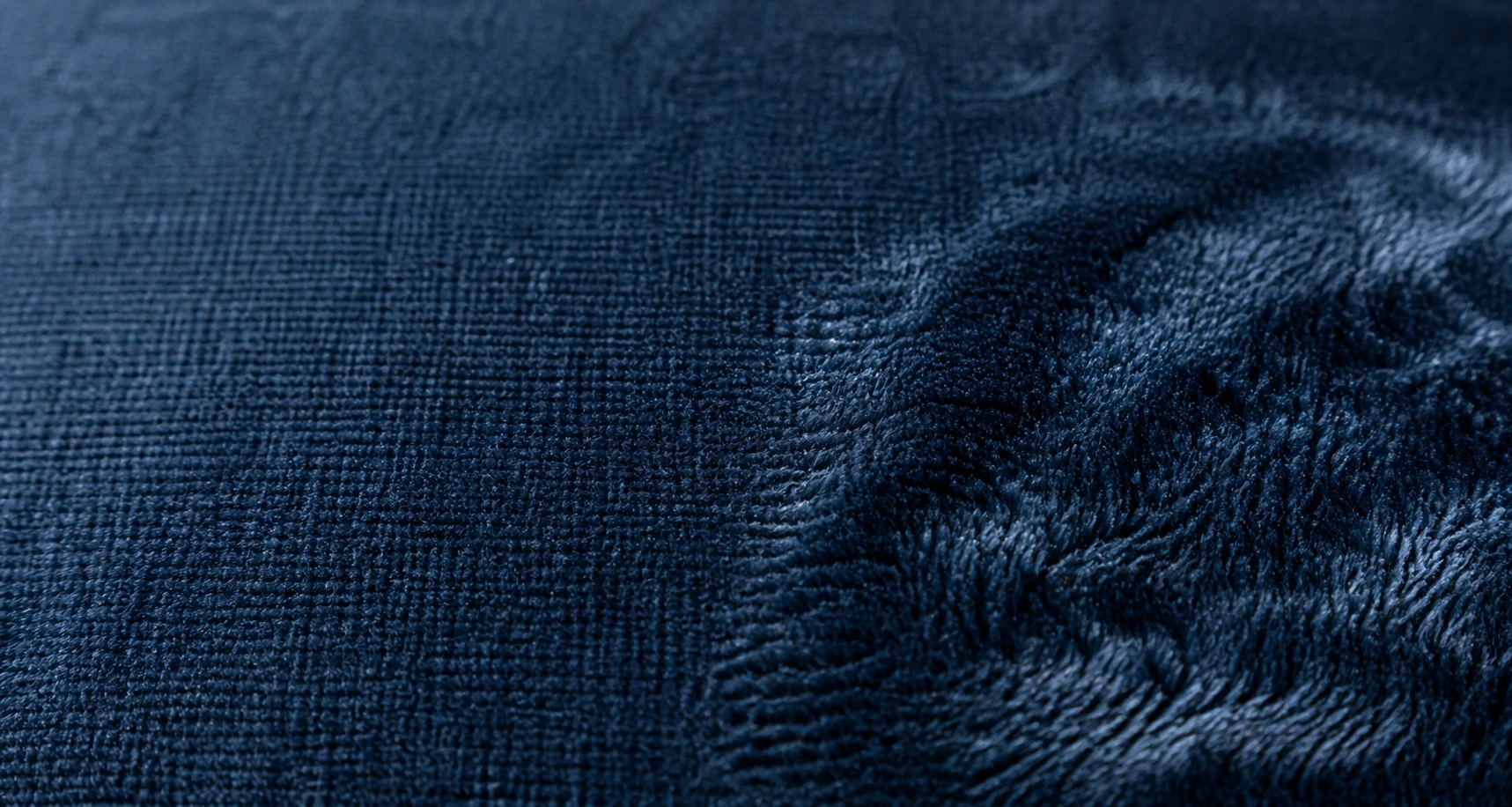 Close-up of velvet fabric texture showing the dense soft pile fibers of a sofa
